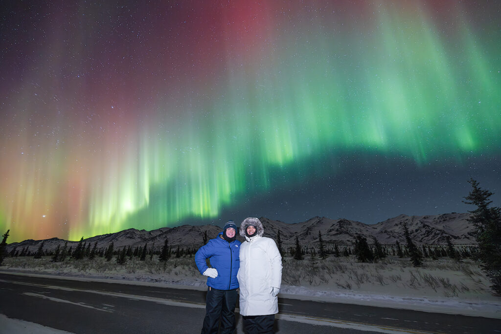 Northern lights dancing over a dark Alaskan landscape showing what a strong alaska aurora forecast delivers on a clear night