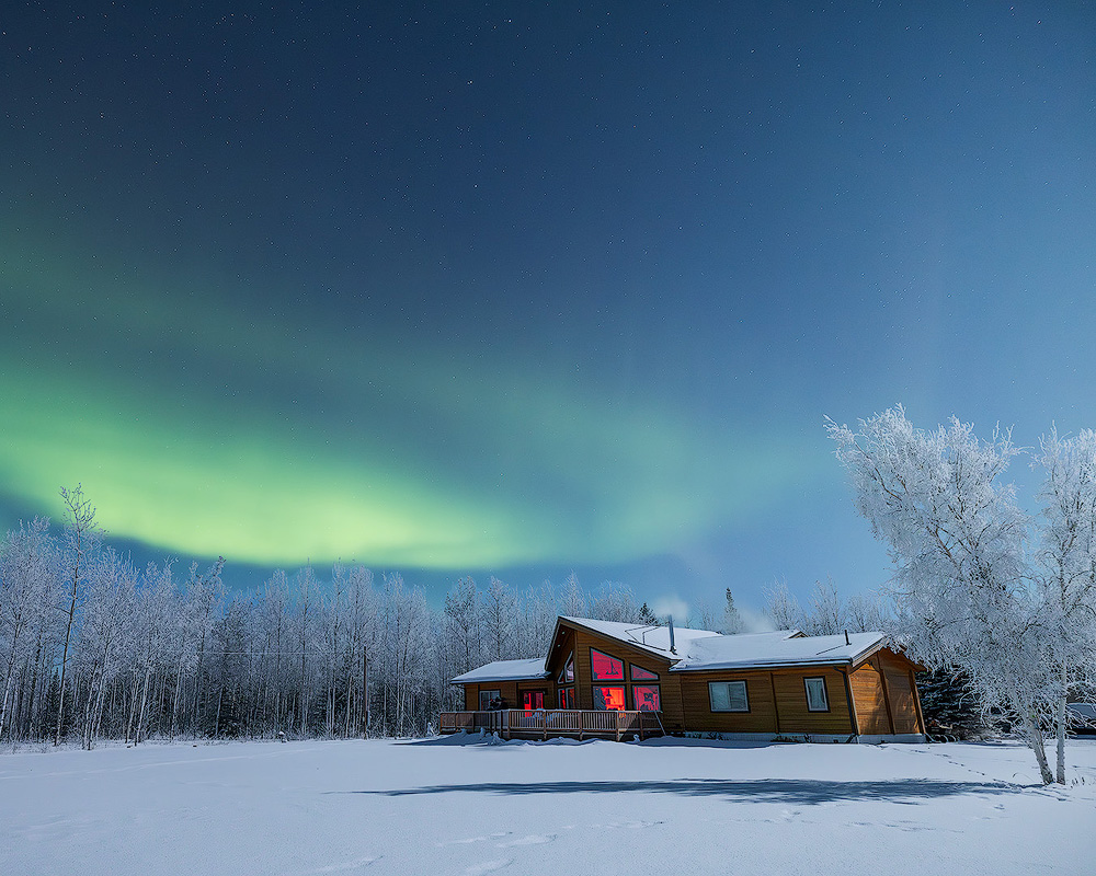 Face The Outdoors private aurora viewing lodge at night under northern lights deep in Alaska's interior with zero light pollution